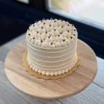 Salted Caramel cake finished with bubble-piped cream, with white and chocolate pearls