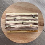 Top of coffee tres leches cake with striped icing and gold decoration