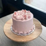 Pink cake with vintage rosettes and candy cane decorations