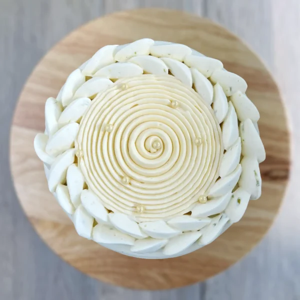 lime-soaked vanilla cake showing passionfruit curd and vanilla mousse layers, finished with lime whipped ganache and pearl decoration