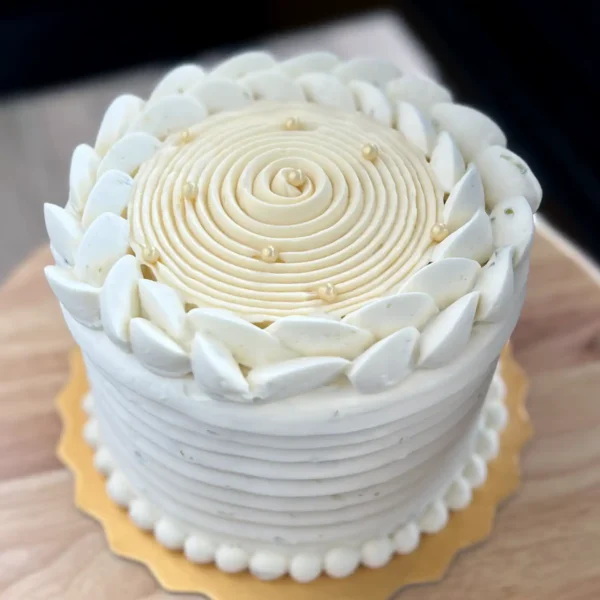 Close-up of passionfruit lime cake finished with whipped ganache topped with elegant textures.