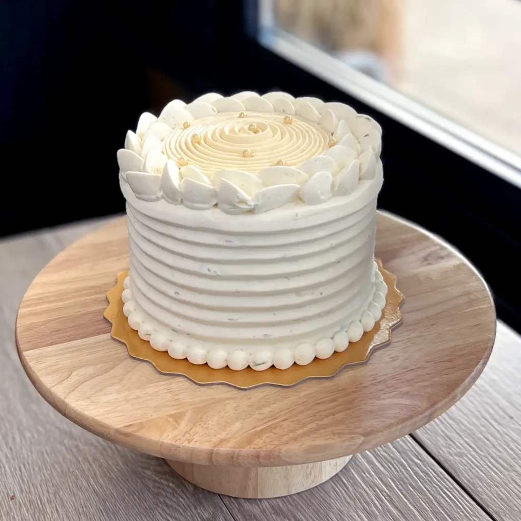 Elegant lime-soaked vanilla cake layered with passionfruit curd and vanilla mousse, topped with lime whipped ganache