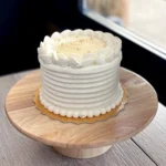 Elegant lime-soaked vanilla cake layered with passionfruit curd and vanilla mousse, topped with lime whipped ganache