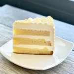 Passionfruit lime cake slice with layers of vanilla sponge, passionfruit curd, and lime cream, Trafiq Bakery Vancouver