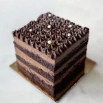 Chocolate Decadence cake — layers of dark Devil's food cake and bittersweet chocolate mousse, topped with star-piped ganache rosettes, white chocolate pearls and silver sugar pearls